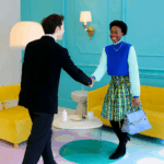 People shaking hands in a colorful, modern room symbolizes professional introductions and networking.