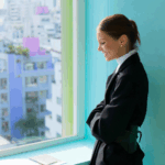 Collage of four women in stylish outfits, posing by windows with city views and vibrant interiors.