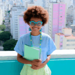 Four stylish individuals in vibrant outfits, standing against a colorful city backdrop.
