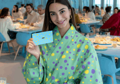 Four stylish individuals in colorful outfits at an event with cityscape views.